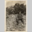 Man sitting on rocky hillside (ddr-densho-466-361)