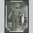 Tets Oye holding small fish (ddr-densho-540-84)