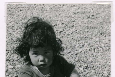 Susan Isoshima sitting on rocky beach (ddr-densho-477-231)