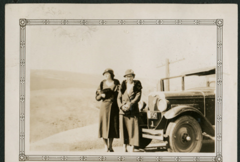 Two women pose in front of car (ddr-densho-359-860)