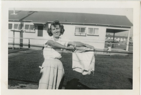 Woman holding up laundry (ddr-manz-7-42)