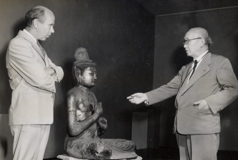 Two art experts admiring a Buddha sculpture (ddr-njpa-2-355)