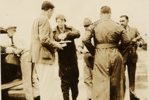 Amelia Earhart and Paul Mantz talking to others at an airfield (ddr-njpa-1-1357)