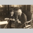 Two men reading a document (ddr-njpa-4-77)