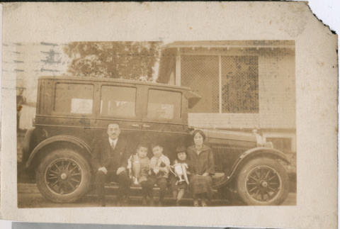 Man, woman and three children sitting on running board of car (ddr-densho-293-100)