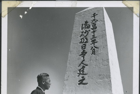 Rev. Shinjo Nagatomi standing in front of the Manzanar cemetery monument (ddr-manz-4-244)
