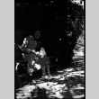 Woman sitting on bench feeding birds (ddr-densho-426-1905)