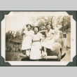 Three sisters sitting on a car (ddr-densho-321-957)