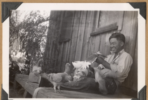 Smiling man with pigeons (ddr-densho-542-51)