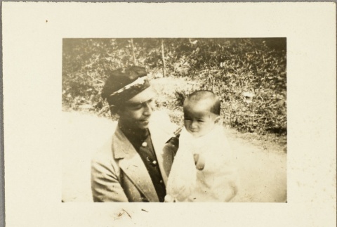 Photo of a man holding a baby (ddr-njpa-13-1249)