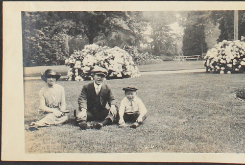 A couple and child seated in a park (ddr-densho-278-112)