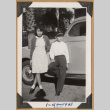Two children pose by a car (ddr-densho-542-206)