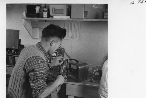 M. Sekijima working in the radio repair shop (ddr-fom-1-842)