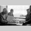 Loni Ding, Barry Saiki, Harry Fukuhara and one other looking through clippings (ddr-densho-1007-1170)