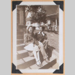 Photo of a man and woman sitting on steps (ddr-densho-483-448)