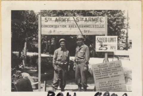 Two men standing under 5th Army sign (ddr-densho-466-364)