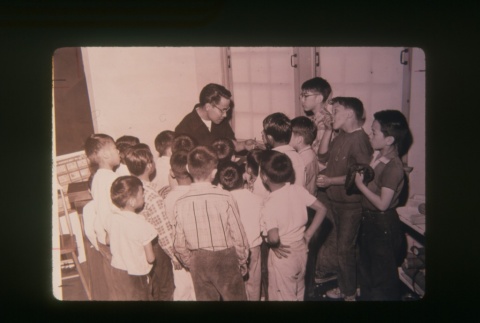 (Slide) - Image of man with children in classroom (ddr-densho-330-175-master-547a513576)