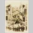 A small crowd watching men work in the rubble of a bombed home (ddr-njpa-13-267)