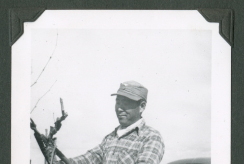 Man using a tool in a field (ddr-densho-471-191)