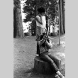 Carole Morita and Peter Horikoshi on a tree stump (ddr-densho-336-498)