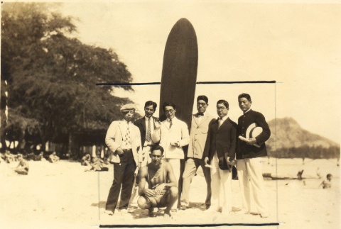 Young men posing with a surfboard (ddr-njpa-4-2791)