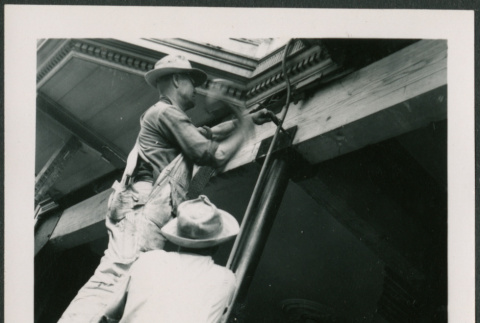 Two men working on support post, one hammering (ddr-densho-426-2261)