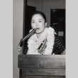 Woman wearing leis speaking at a podium (ddr-njpa-2-710)