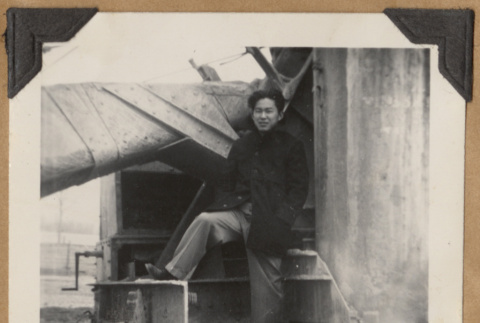 Man posing on large piece of equipment (ddr-densho-542-137)