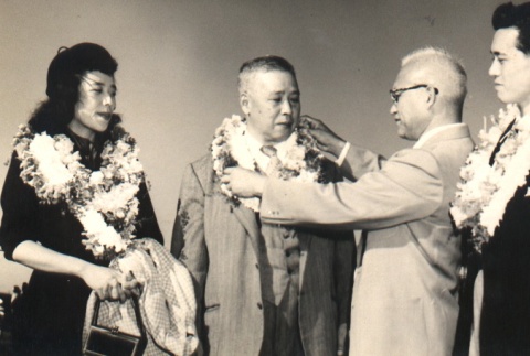 Utashito Nakashima, his daughter and a koto player receiving leis (ddr-njpa-4-1318)