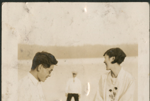 Couple sitting on a seawall with record player (ddr-densho-316-174)