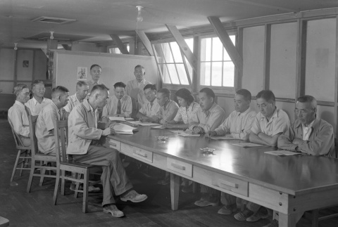Group reading documents in an office barracks (ddr-fom-1-391)
