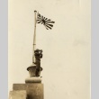 A soldier looking through binoculars under a Japanese flag (ddr-njpa-6-43)