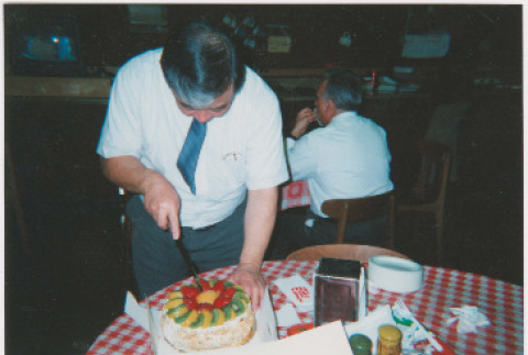 Dave Sato cutting cake (ddr-densho-426-1211)