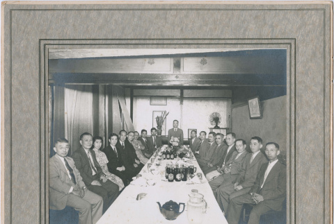 Group portrait on men and one woman seated around long table (ddr-densho-410-394)