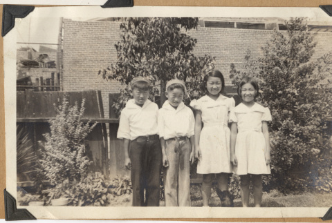 Four children smiling outdoors (ddr-densho-542-178)