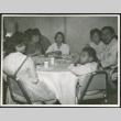 Group of adults and one child sitting at a table eating (ddr-densho-293-179)