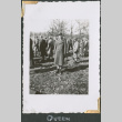 Man in uniform standing in field with others (ddr-densho-434-44)