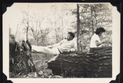 Man poses across a fallen tree (ddr-densho-542-754)