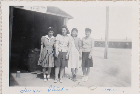 Four woman standing outside building with sign, Station 21-27 (ddr-densho-464-22)
