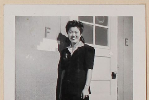 Emmy Sumida Ito in front of her barrack door at Amache Relocation Center (ddr-densho-379-683)