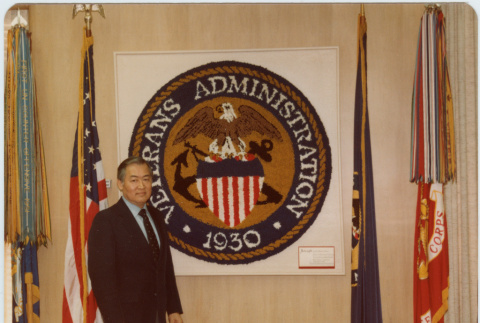 Frank Sato poses with Veterans Administration seal (ddr-densho-345-58)