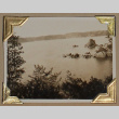Body of water surrounded by rocky cliffs and trees (ddr-densho-404-217)