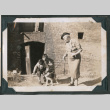 Photo of two children petting a dog held on a leash by an elderly woman (ddr-densho-483-851)