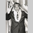 Man wearing lei, making victory sign in front of flag (ddr-njpa-2-304)