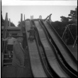 Man standing by slide with two children (ddr-densho-426-927)