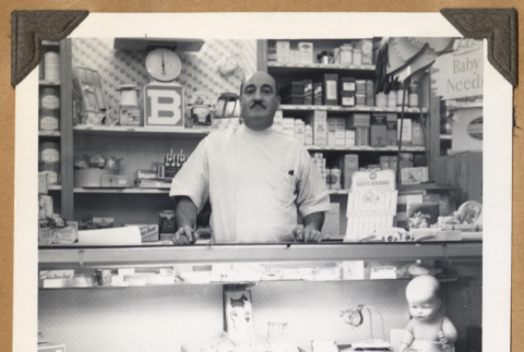 Man standing behind a glass case (ddr-densho-542-106)