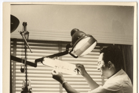 Dentist examining x-rays (ddr-densho-542-799)