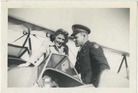 Woman and serviceman next to a biplane (ddr-manz-7-108)