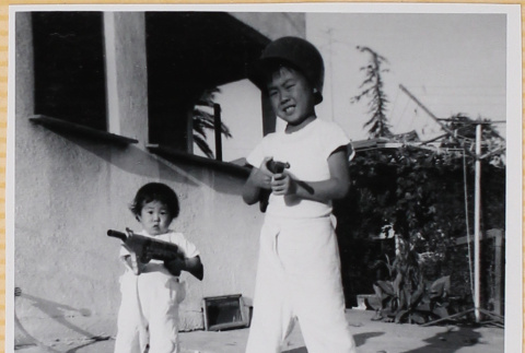 Susan Shiomi playing with toy gun with William Shiomi (ddr-densho-522-272)