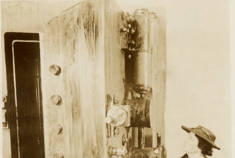 A woman standing next to a museum piece (ddr-njpa-1-1556)